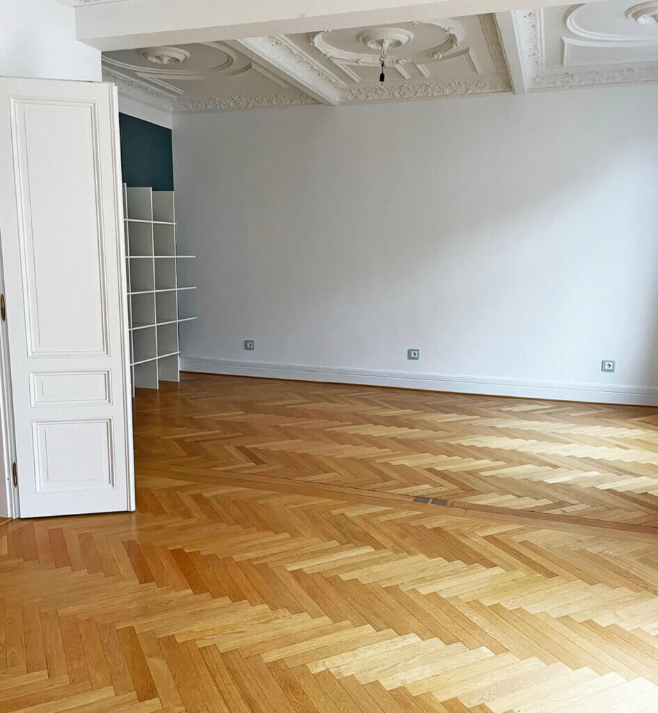 Aufgearbeitetes Fischgrätparkett in einem Frankfurter Altbau mit Stuckdecke