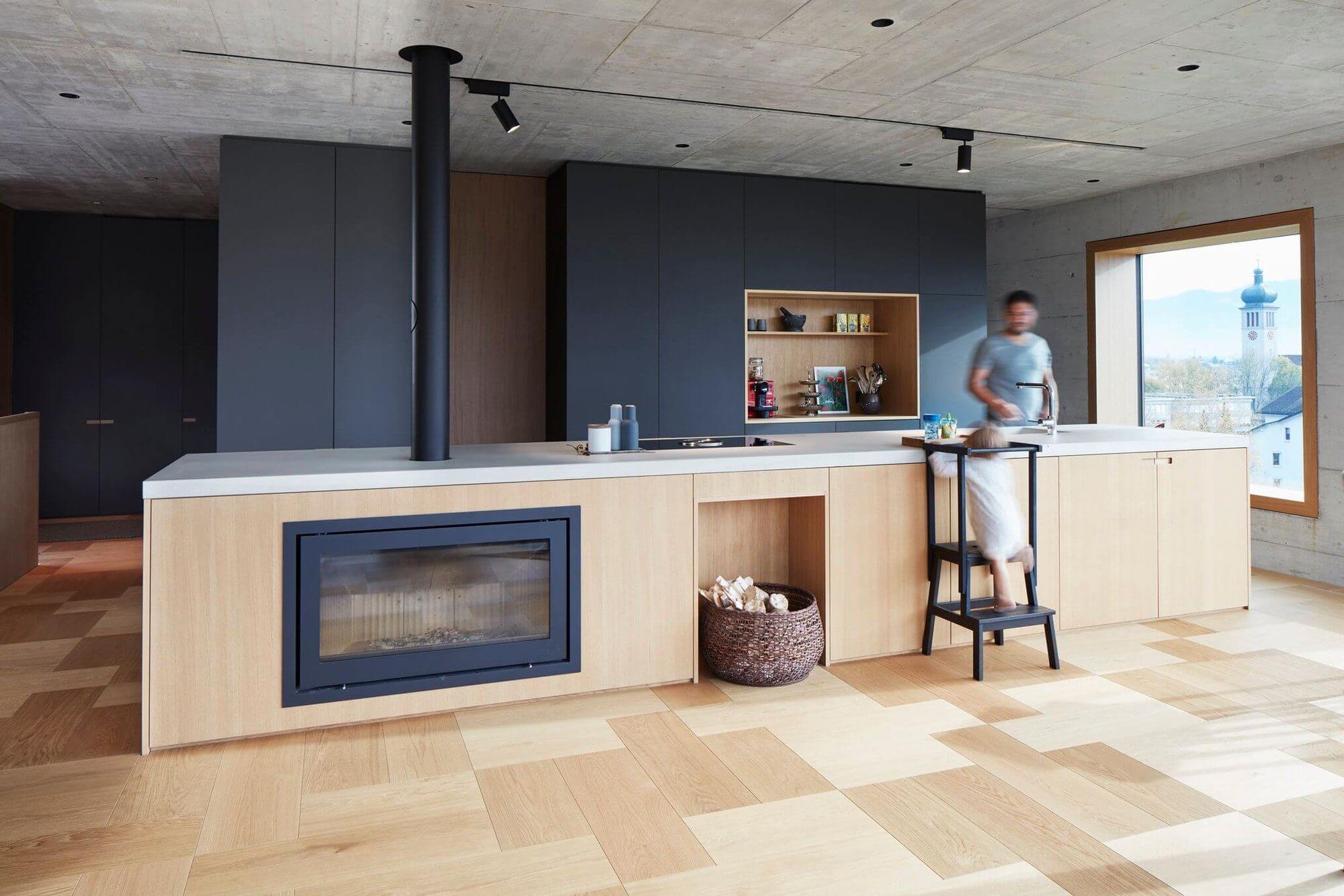 Offene Wohnküche mit Kamin und Parkettboden von Bauwerk Parkett