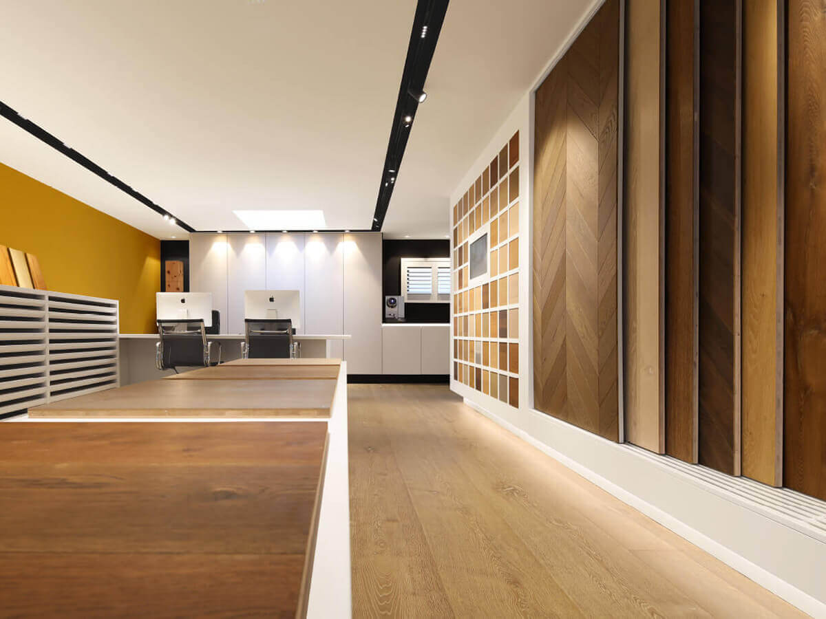 Ausstellungsraum mit langer Mustertheke und Parkettmustern an der Wand im Showroom in Friedrichsdorf